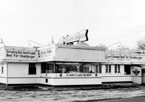 Single-story white building with arrow-shaped Steak n Shake sign on roof